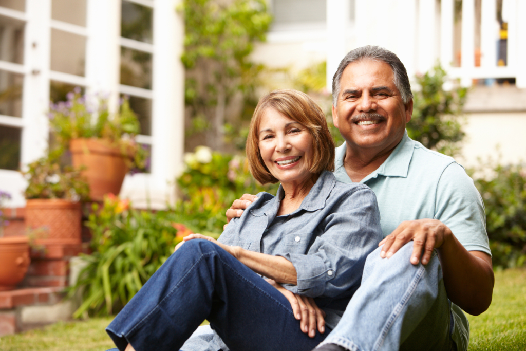 Couple relaxing in front of house