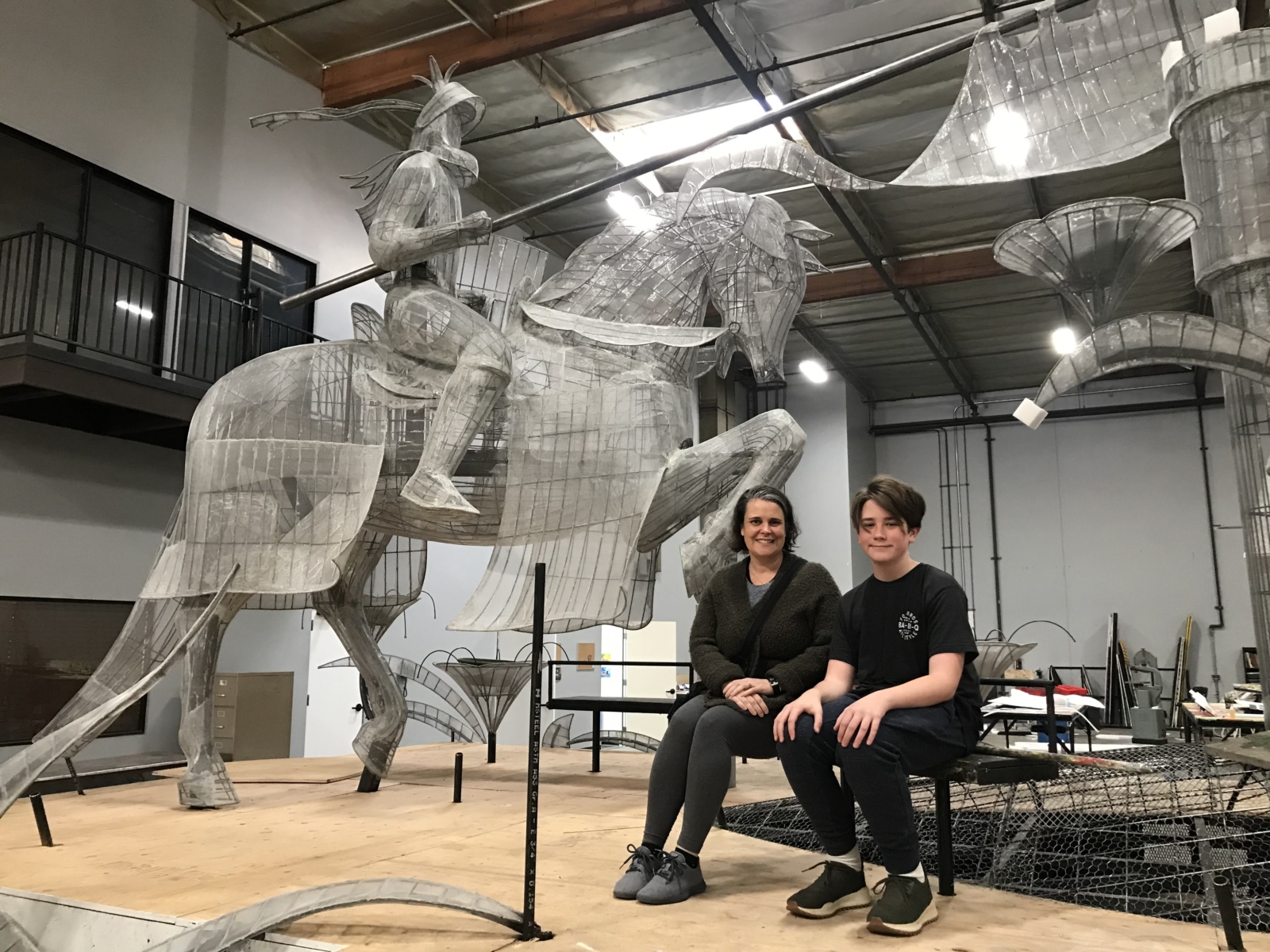 Two people sitting in front of knight and horse