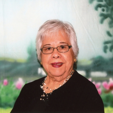 Asian woman smiling in front of floral backdrop