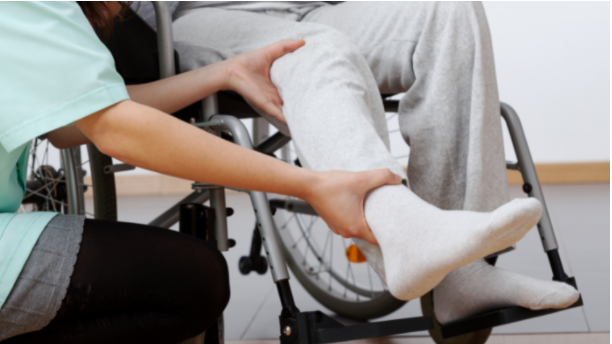 Caregiver holding person's ankle 