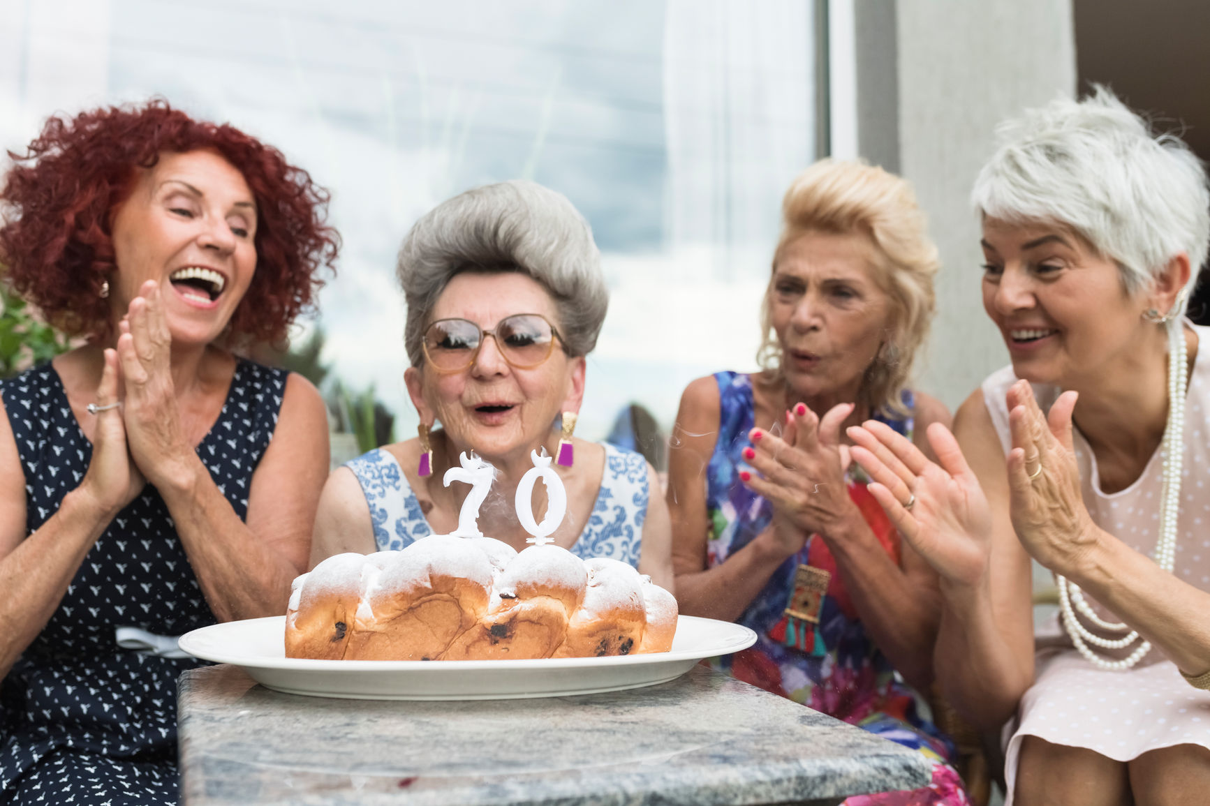 Playful happy seniors women having fun at birthday party.