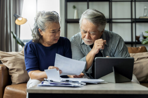 Older adult Asian couple going over paperwork