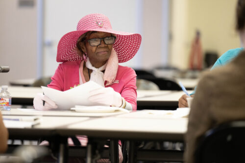 An elderly African-American woman sitting at a table at the listening session in Dallas, TX with the Senior Source